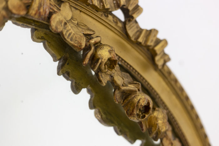 Miroir en bois doré à décor de guirlandes de fleurs et d'un ruban - focus guirlande de fleurs