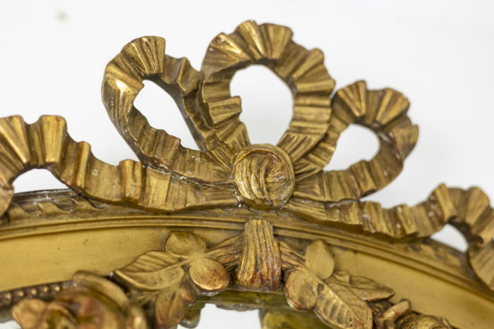 Miroir en bois doré à décor de guirlandes de fleurs et d'un ruban - focus ruban