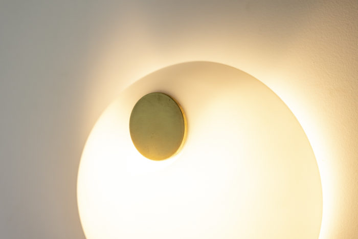 Wall lamp in Murano glass, in white opaline. Brass circular shape in the center