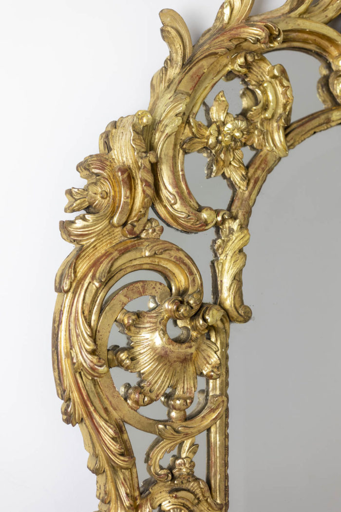 Miroir à parcloses de style Régence en bois doré à la feuille et sculpté, à double encadrements et orné d'une coquille en partie haute. Miroir au mercure - détail