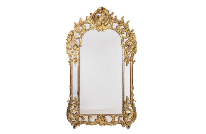 Miroir à parcloses de style Régence en bois doré à la feuille et sculpté, à double encadrements. Miroir au mercure - face